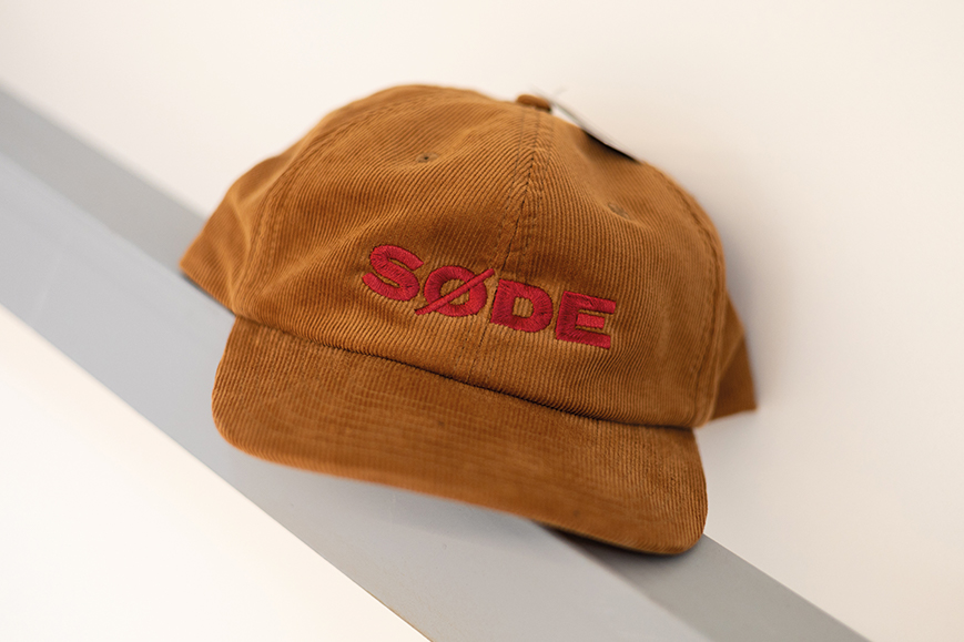 An embroidered cap with Sode's logo in corduroy fabric.